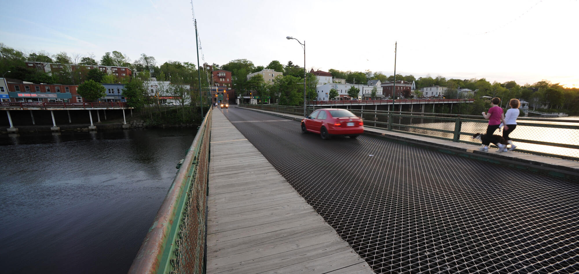 Car passes two women jogging on a bridge over the LaHave River in Bridgewater.