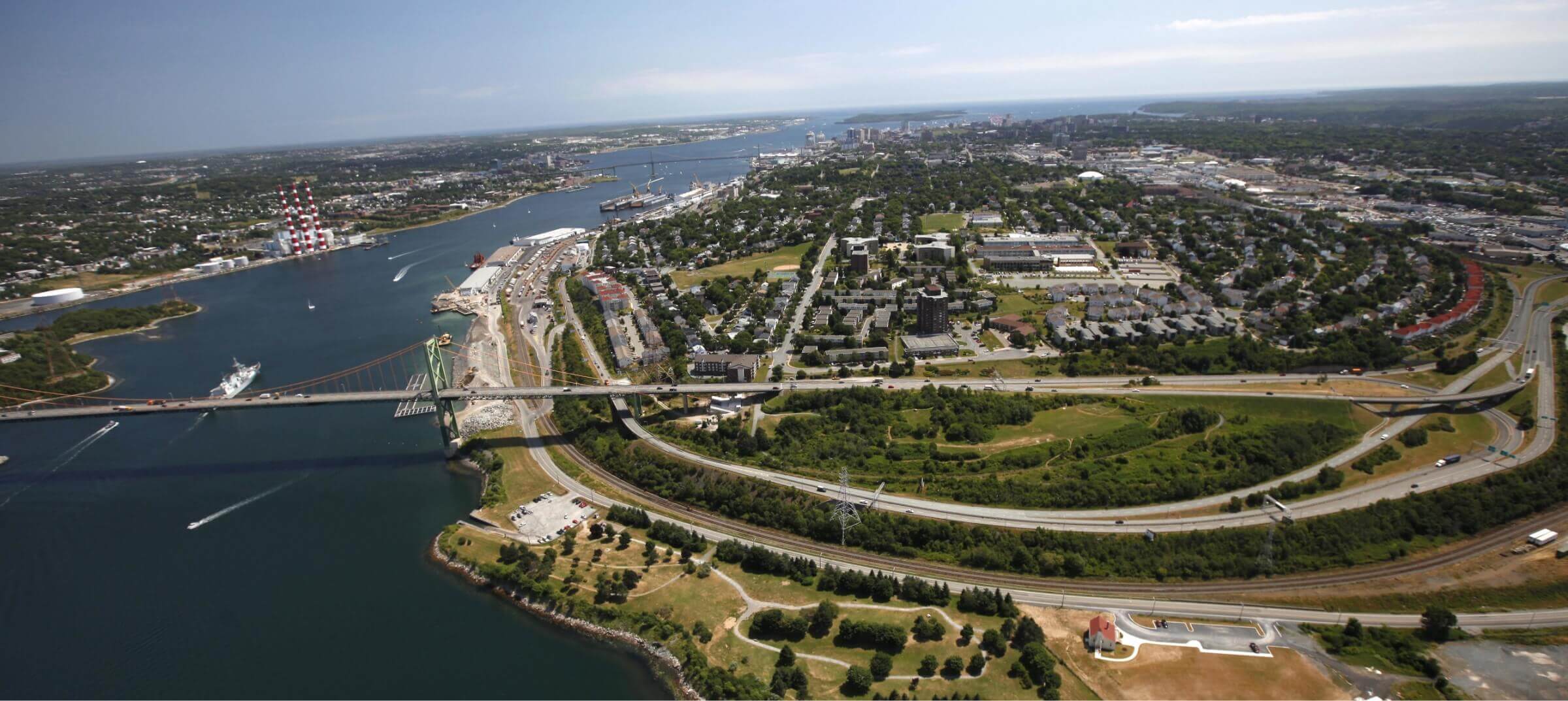 Aerial of the MacKay Bridge, Bedford Basin, the former Africville lands and Africville Park, with the narrows and Tuft's Cove seen further in the background.